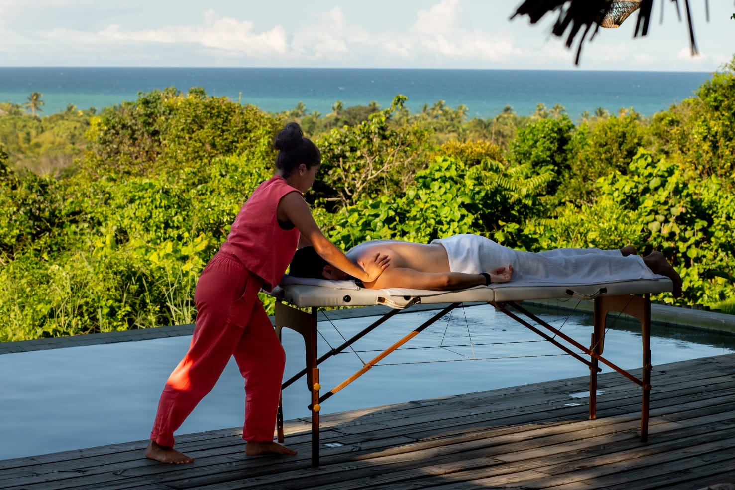 Massagem ao ar livre no deck do Bahia Bonita, com vista para a mata atlântica e o mar de Trancoso ao fundo