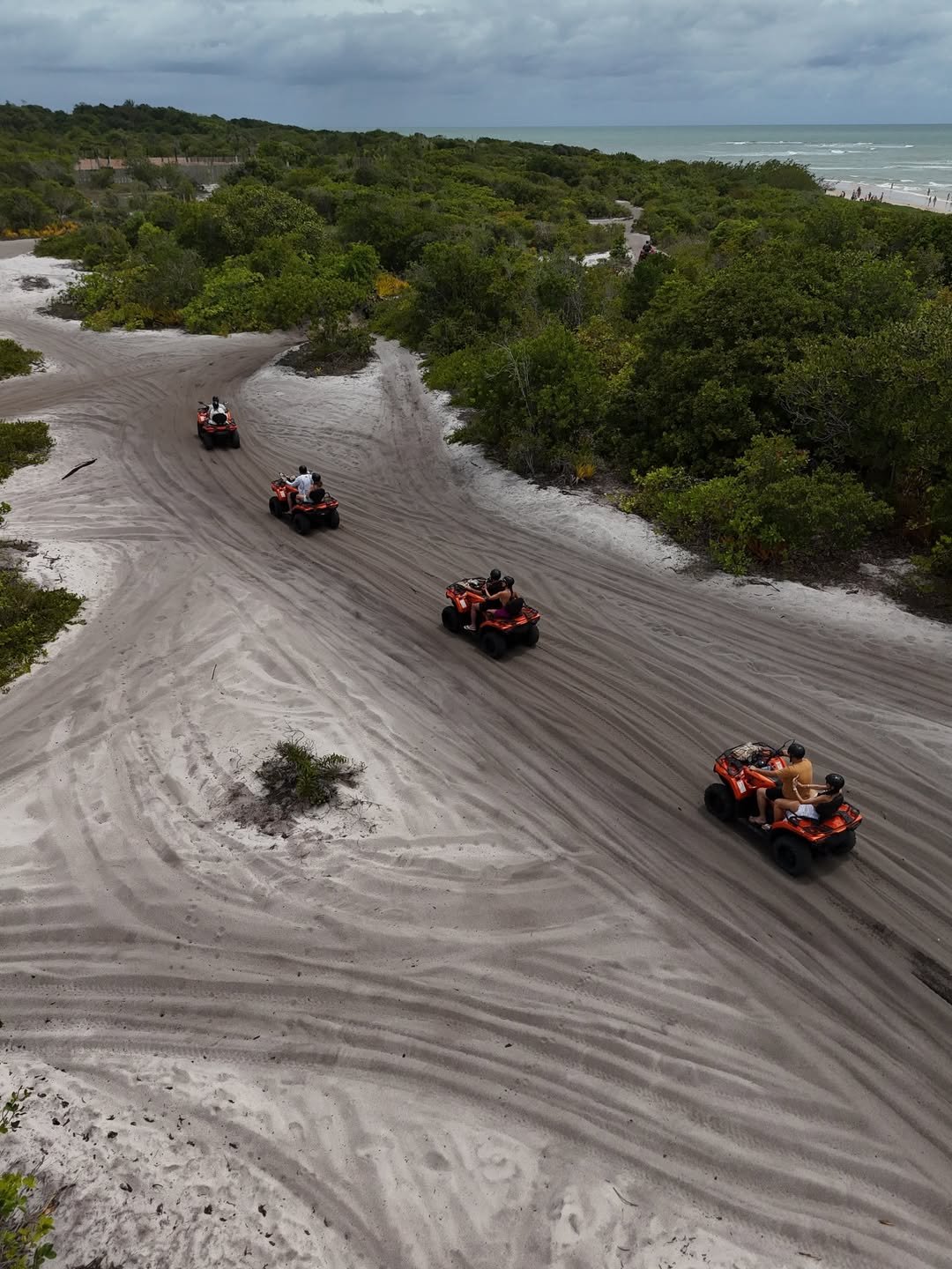 Quadriciclos em trilha de areia entre mata atlântica e praia em Trancoso