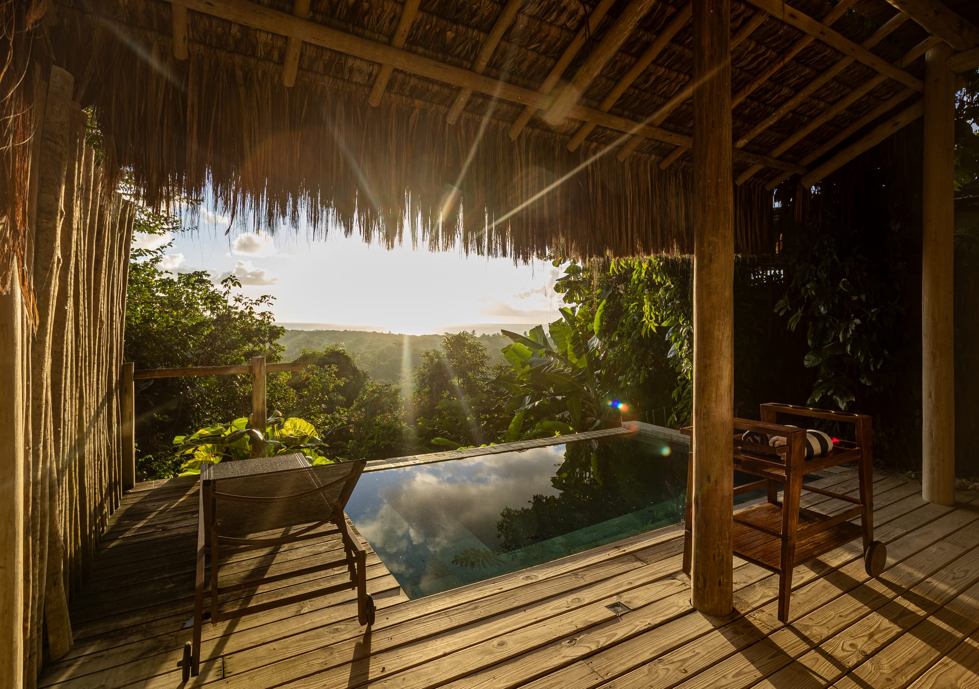 Suíte do Hotel Boutique Bahia Bonita, interior com cama king e mosquiteiro dossel, vista para a piscina e o mar