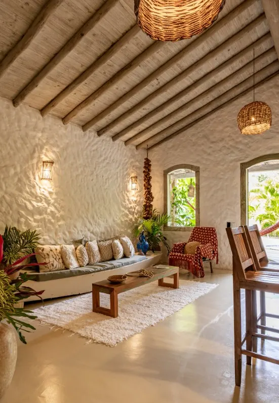 Sala com teto de madeira, luminárias de palha e sofá baixo