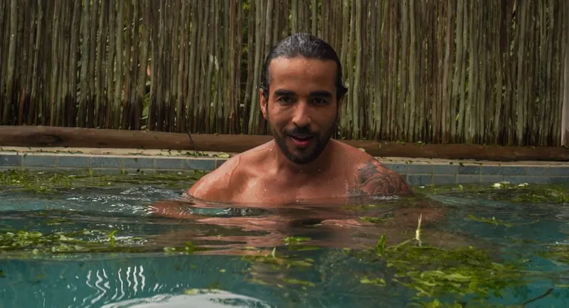Participante sorrindo dentro da piscina de ervas