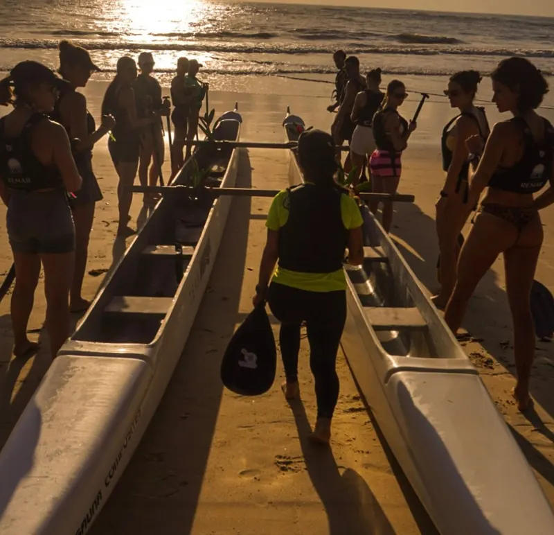 Grupo se preparando para remar na canoa havaiana ao nascer do sol