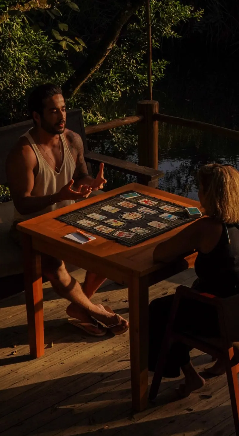 Leitura de cartas à luz do fim de tarde em uma mesa de madeira