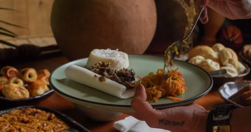 Prato servido com arroz, legumes e pães na mesa do retiro